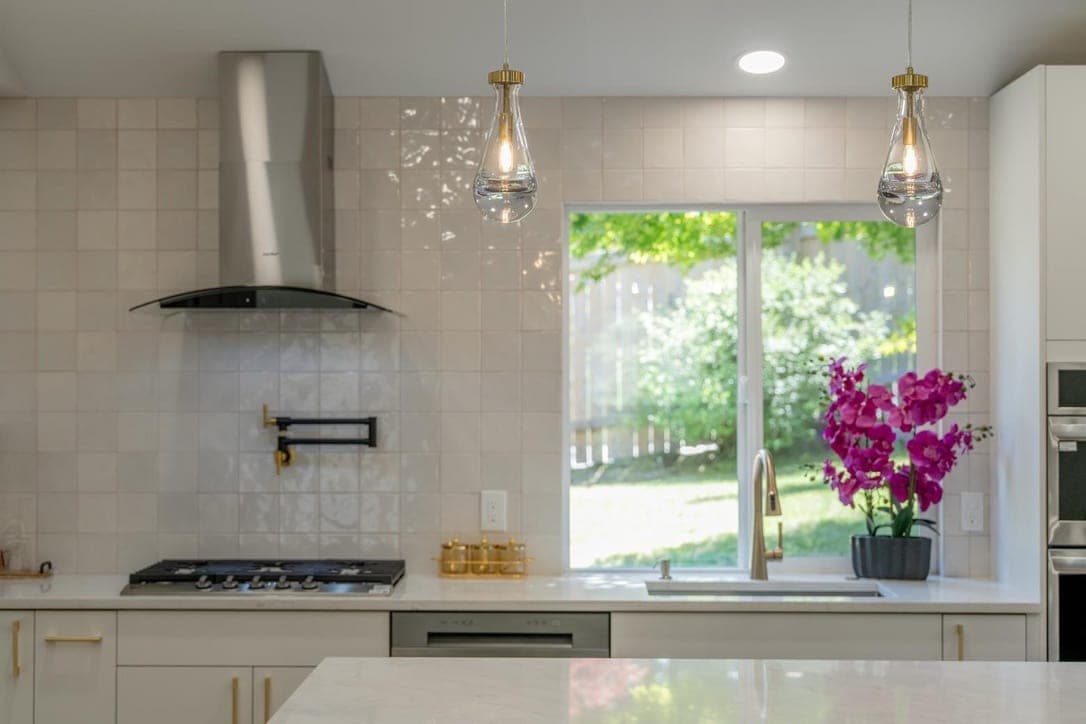 Wide view of the kitchen showing the tiled range wall, window, and island